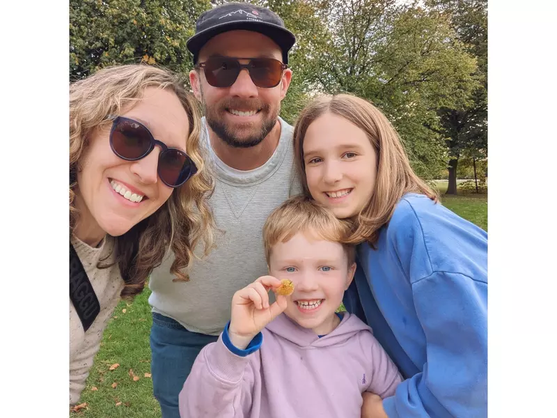 A woman, a man and two children smile for a selfie.