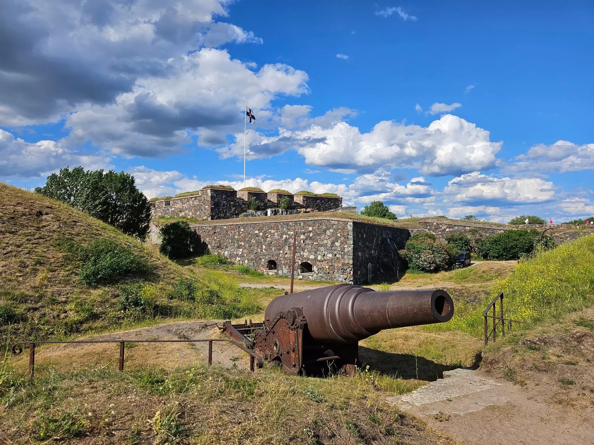 Old cannon and finnish flag at Suomenlinna fortress in Helsinki, License Type: media, Download Time: 2025-02-04T23:10:12.000Z, User: claramonitto, Editorial: false, purchase_order: 56530 - Guidebooks, job: Global Publishing-WIP, client: Scandinavia 15, other: Clara Monitto