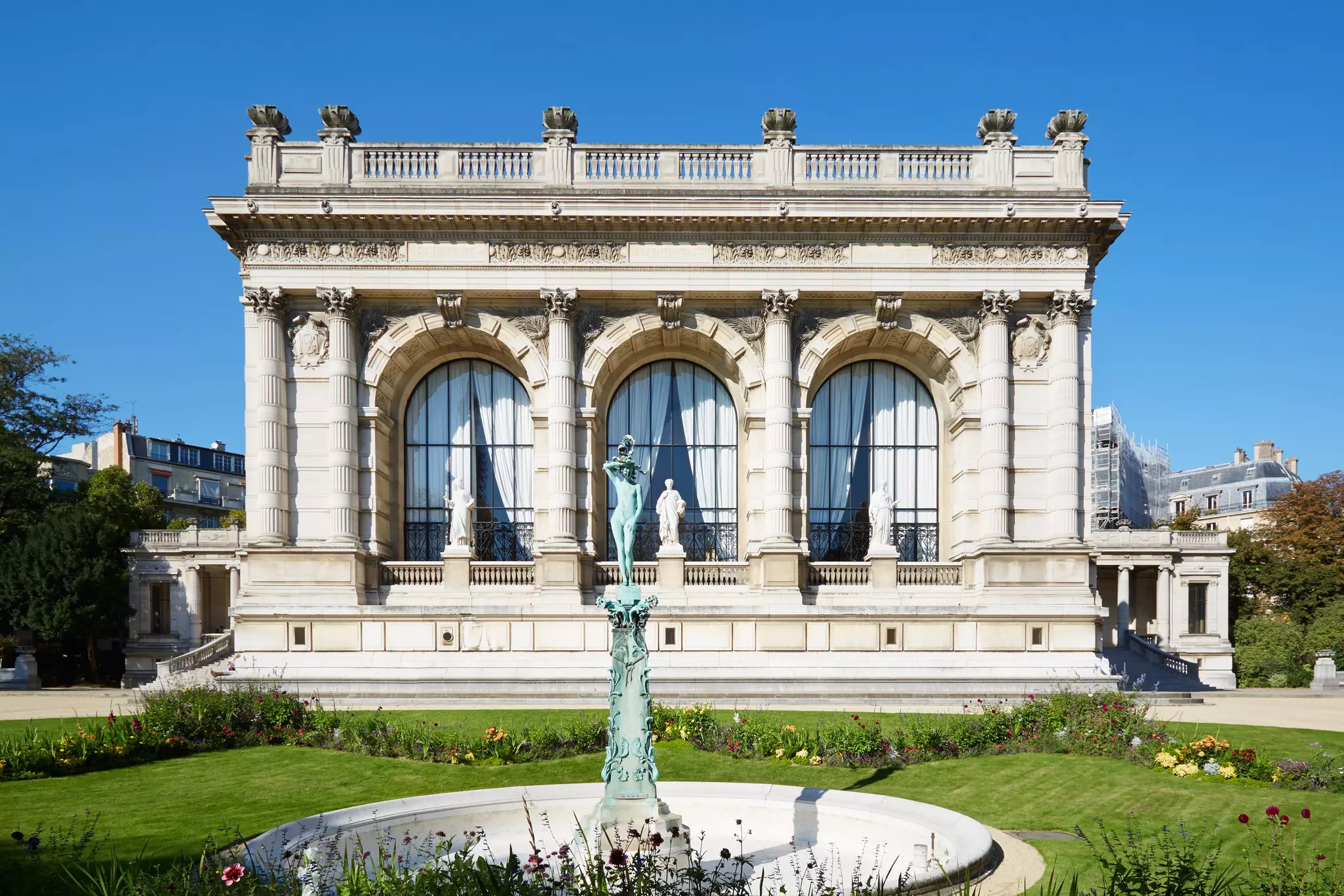 The exterior of a grand building in a neat garden