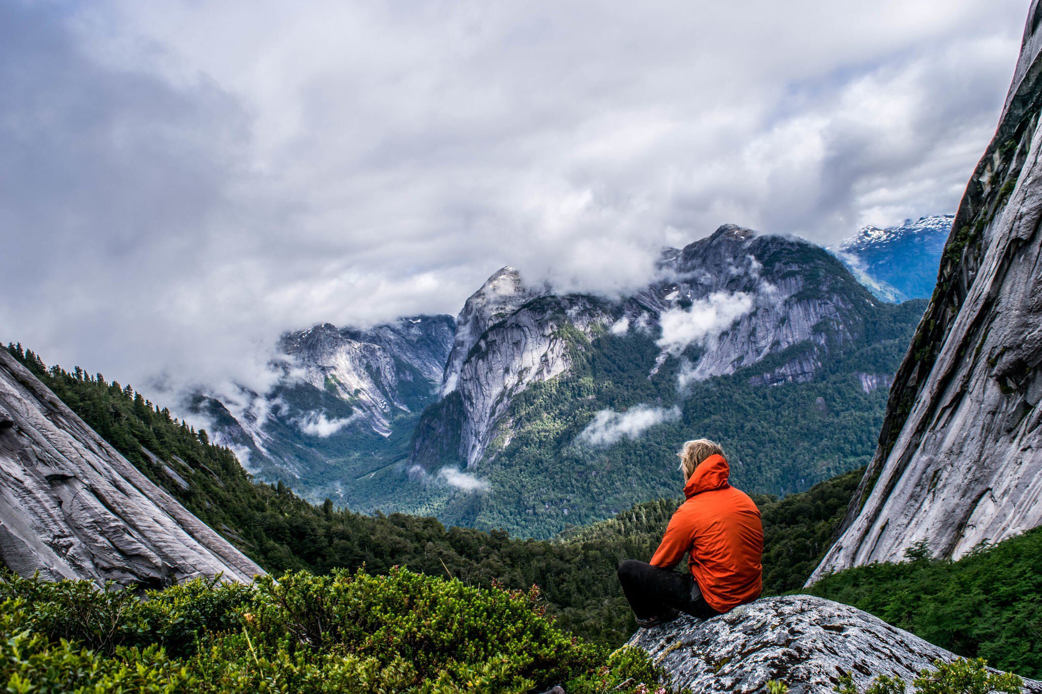 Male hiker sits on a rock at Puerto Montt.