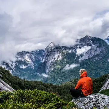 Male hiker sits on a rock at Puerto Montt.