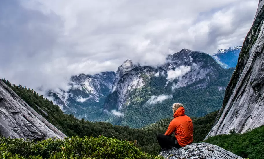 Male hiker sits on a rock at Puerto Montt.