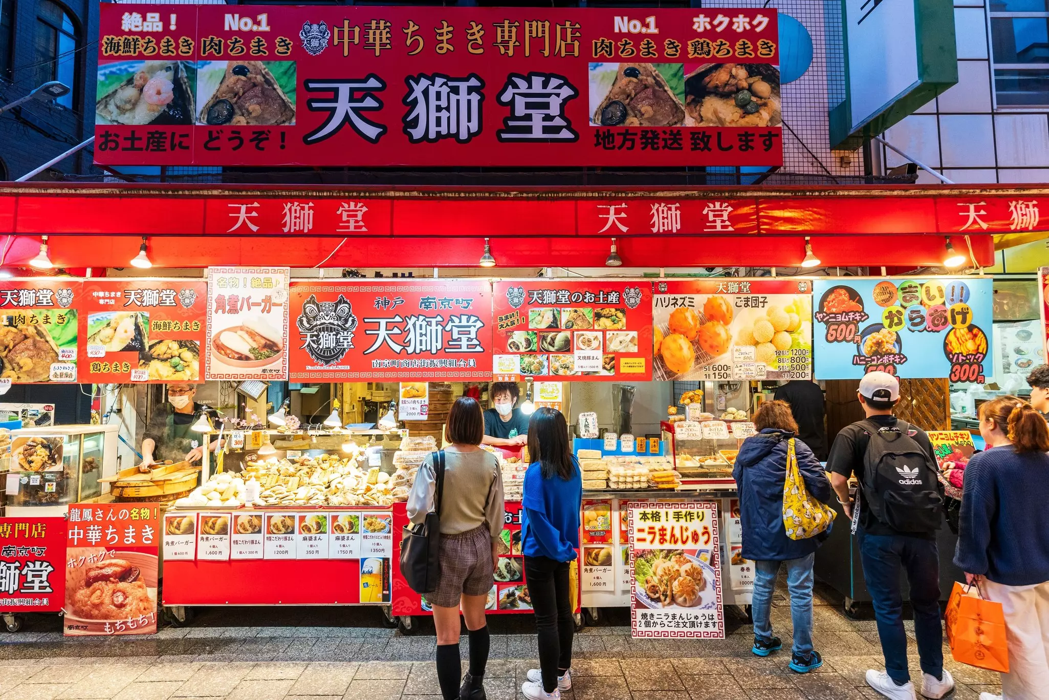 People line up at a food stall selling Chinese delicacies in Kobe