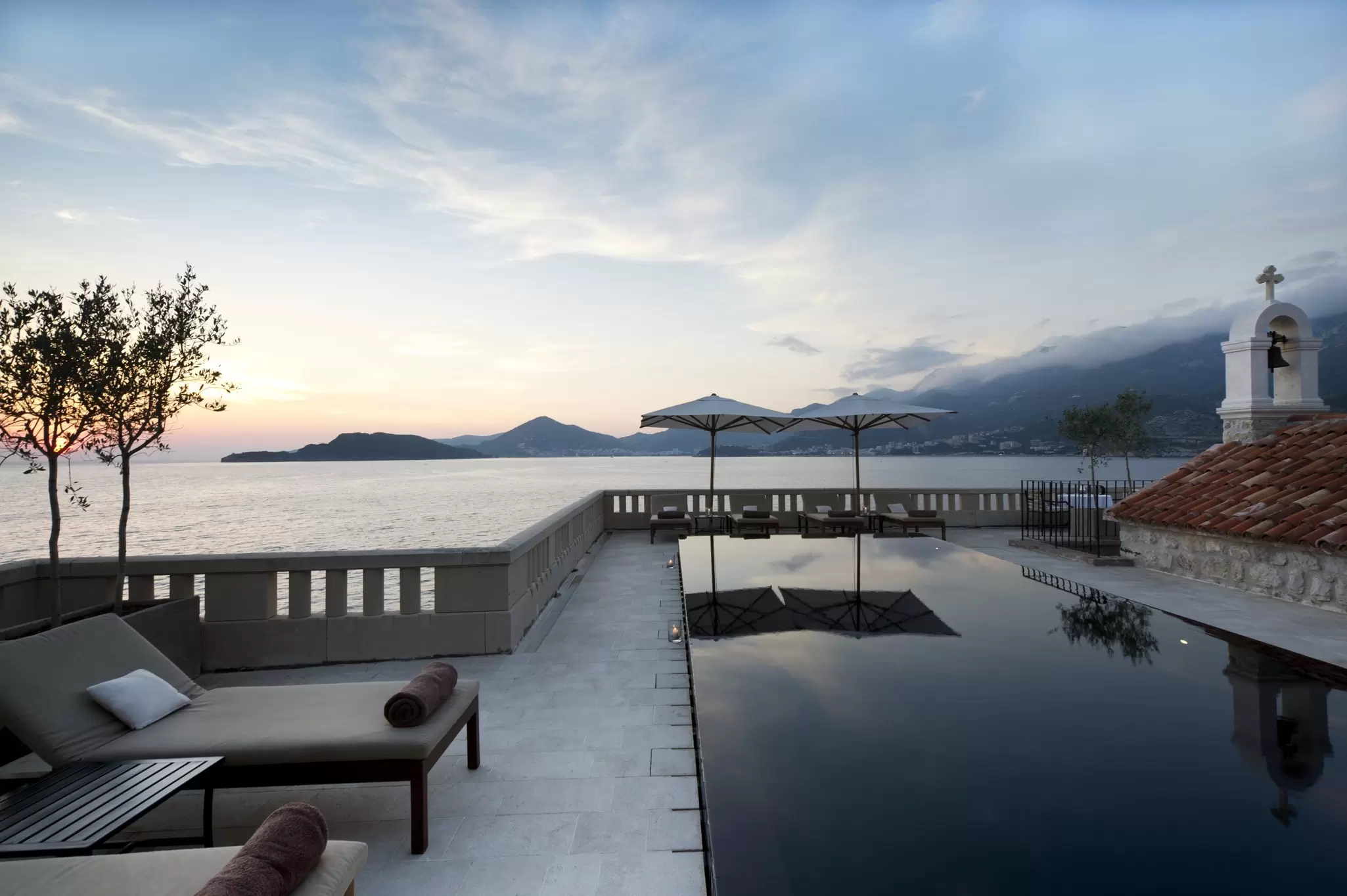 A pool at the edge of the ocean at twilight: Aman Sveti Stefan, Montenegro
