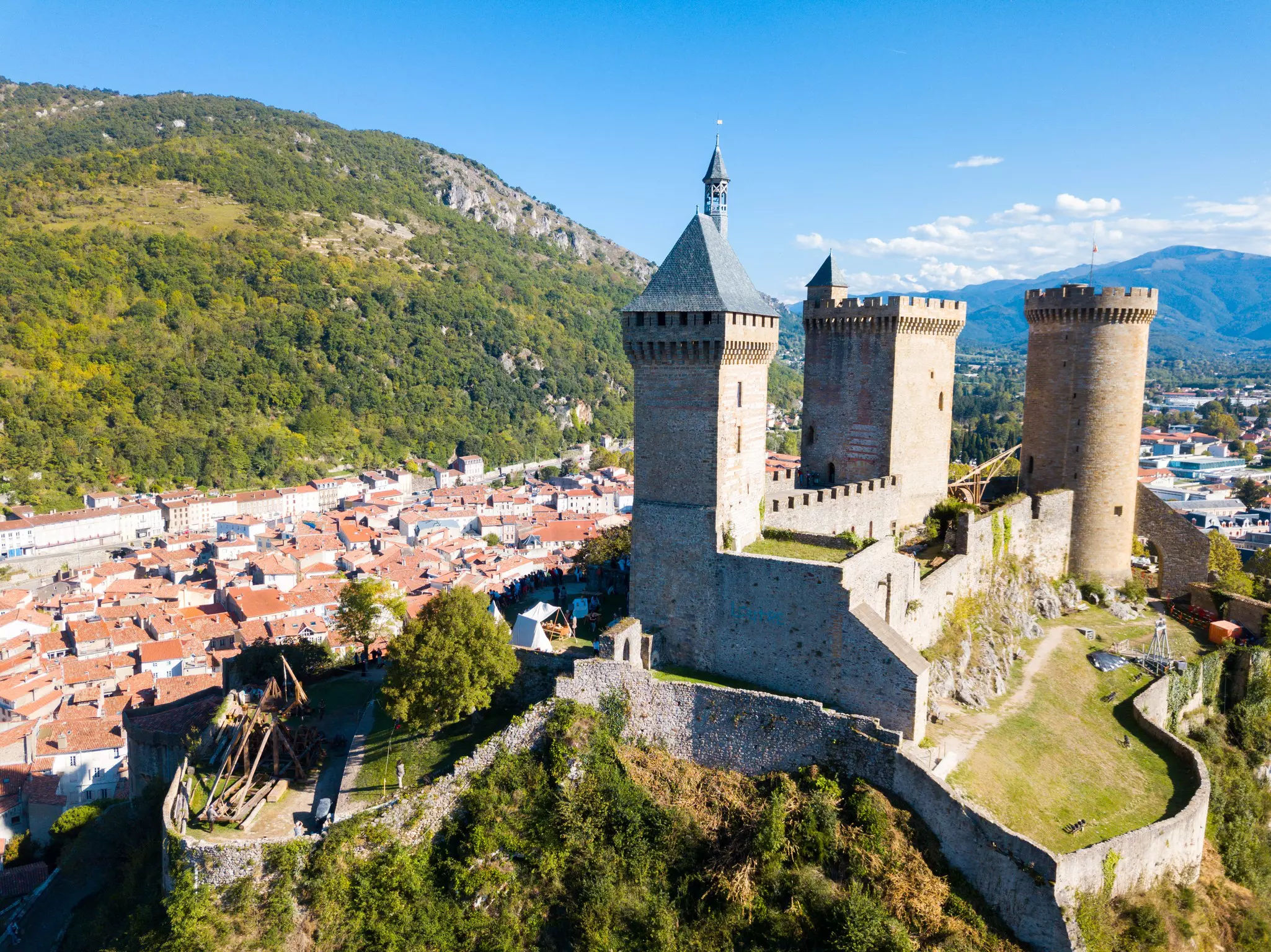 Picturesque autumn landscape with imposing medieval fortress Chateau de Foix on hill, France