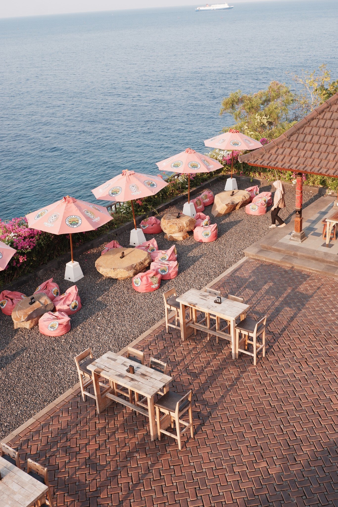 Pink-themed oceanfront cafe setup at Sunset Point café, Amed Beach, Bali, Indonesia on October 25, 2023