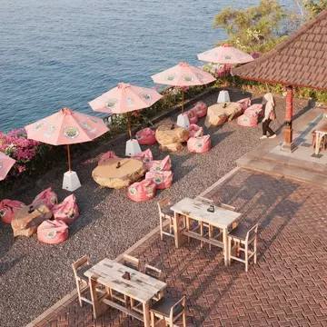 Pink-themed oceanfront cafe setup at Sunset Point café, Amed Beach, Bali, Indonesia on October 25, 2023