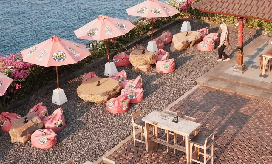 Pink-themed oceanfront cafe setup at Sunset Point café, Amed Beach, Bali, Indonesia on October 25, 2023
