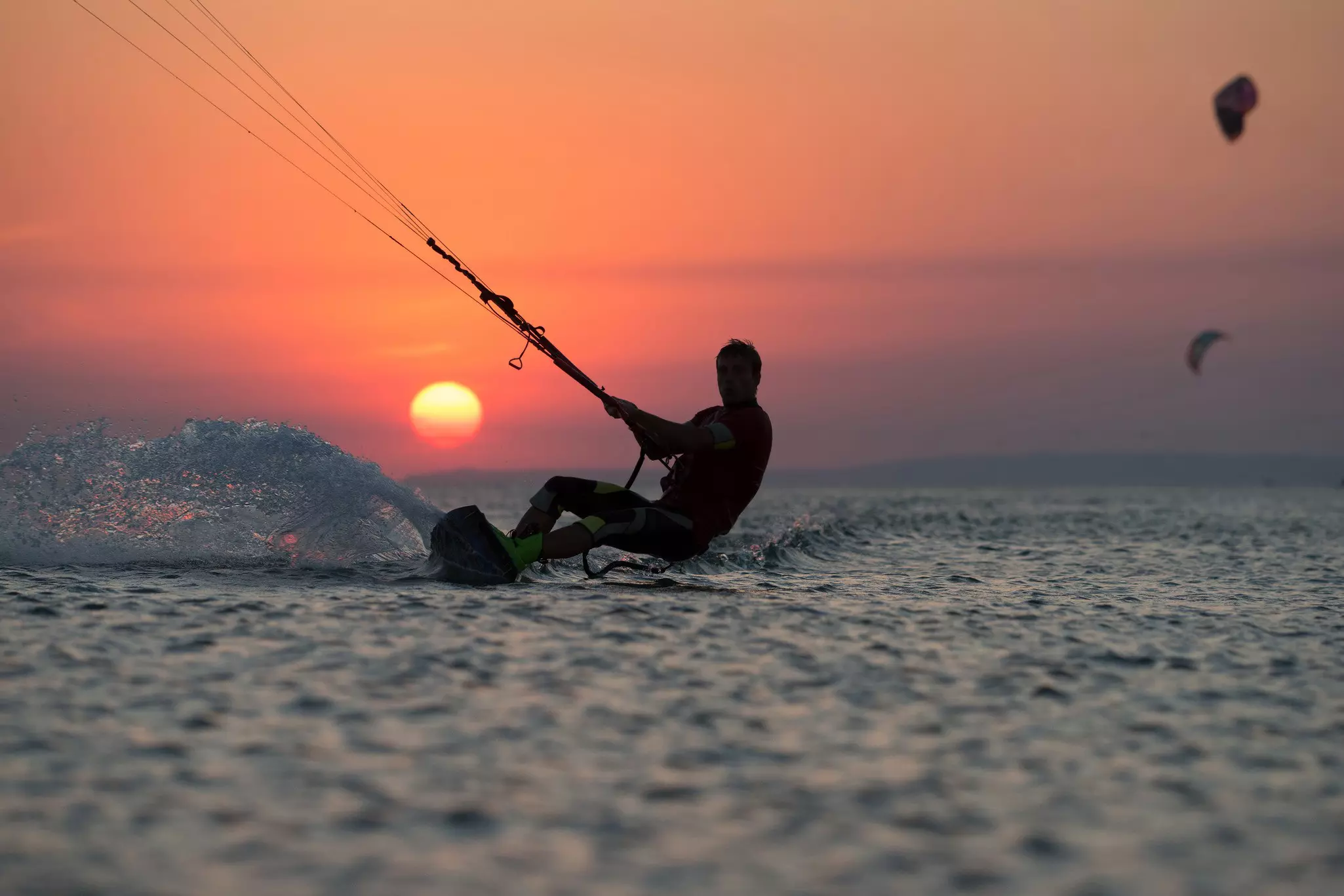 Kiteboarder at sunset. ohrimalex / Getty Images