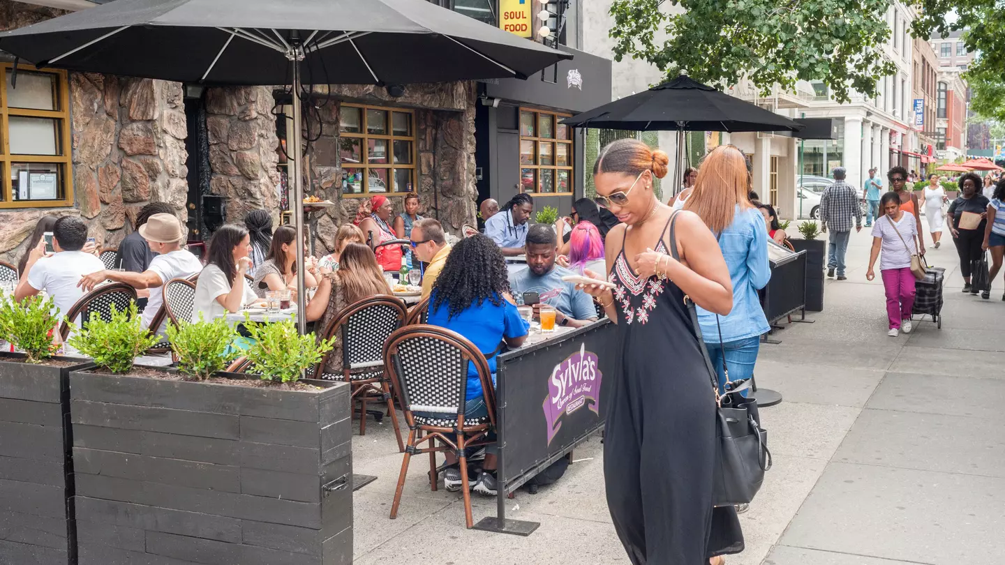 Al fresco dining outside the world-renowned Sylvia's restaurant in Harlem, New York
