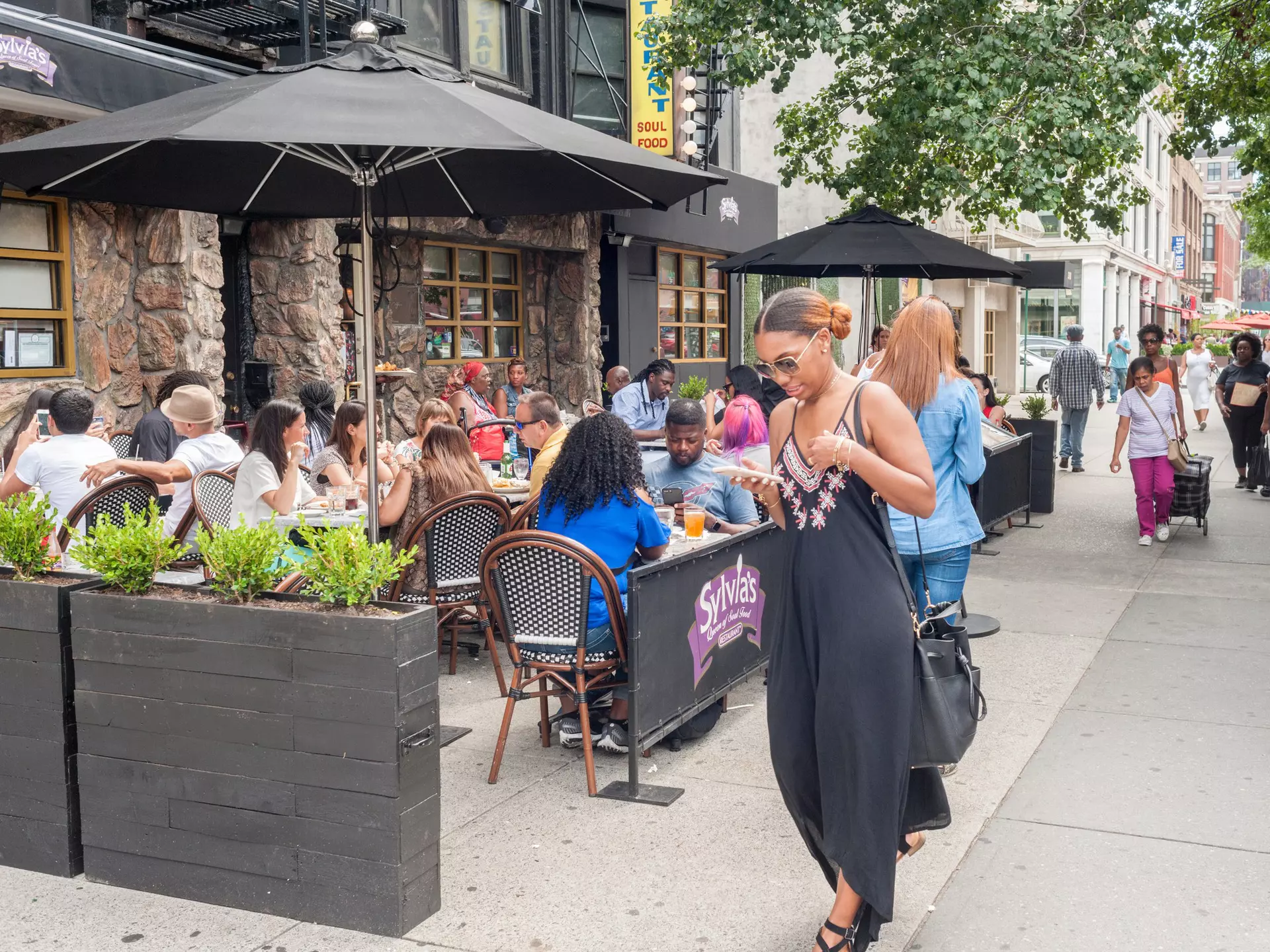 Al fresco dining outside the world-renowned Sylvia's restaurant in Harlem, New York