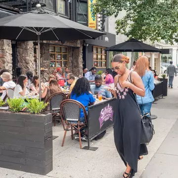 Al fresco dining outside the world-renowned Sylvia's restaurant in Harlem, New York