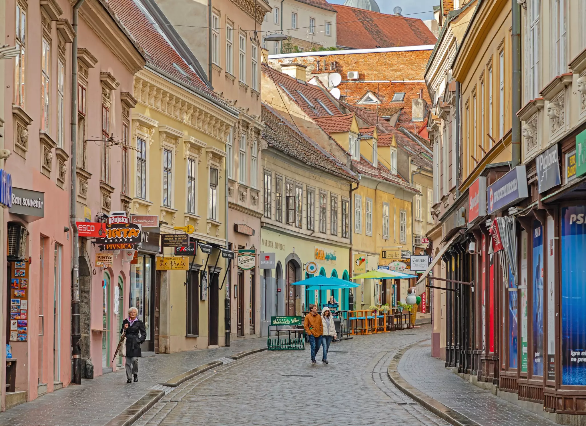Pubs and souvenir shops in close, colorful buildings along a pedestrian street