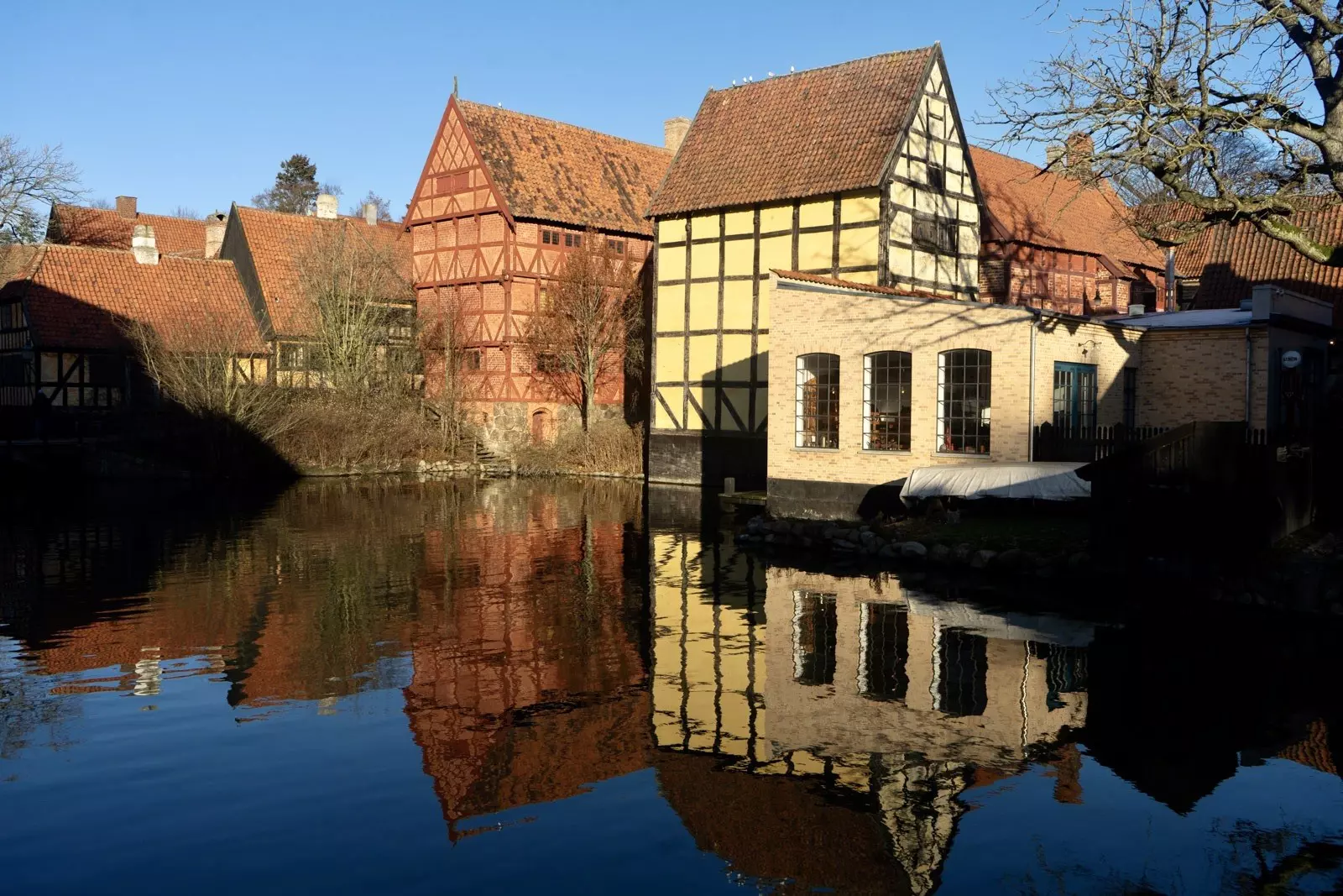 Water reflect the historic buildings of Den Gamle By near Aarhus. A Lonely Planet writer took this image.