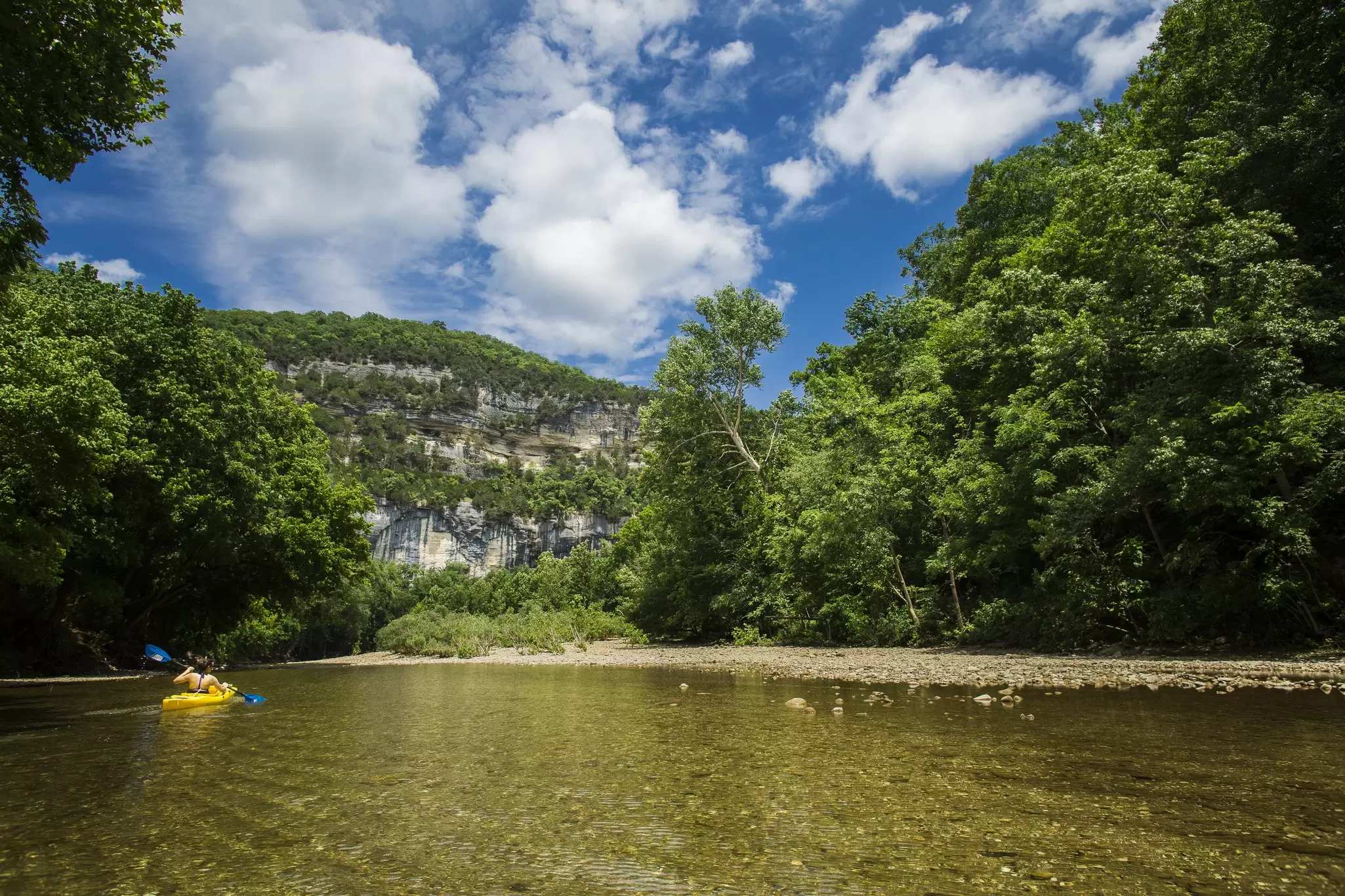 A view from the Buffalo River with a kayaker looking towards Big Bluff and the Goat Trail. Gunnar Rathbun/Shutterstock