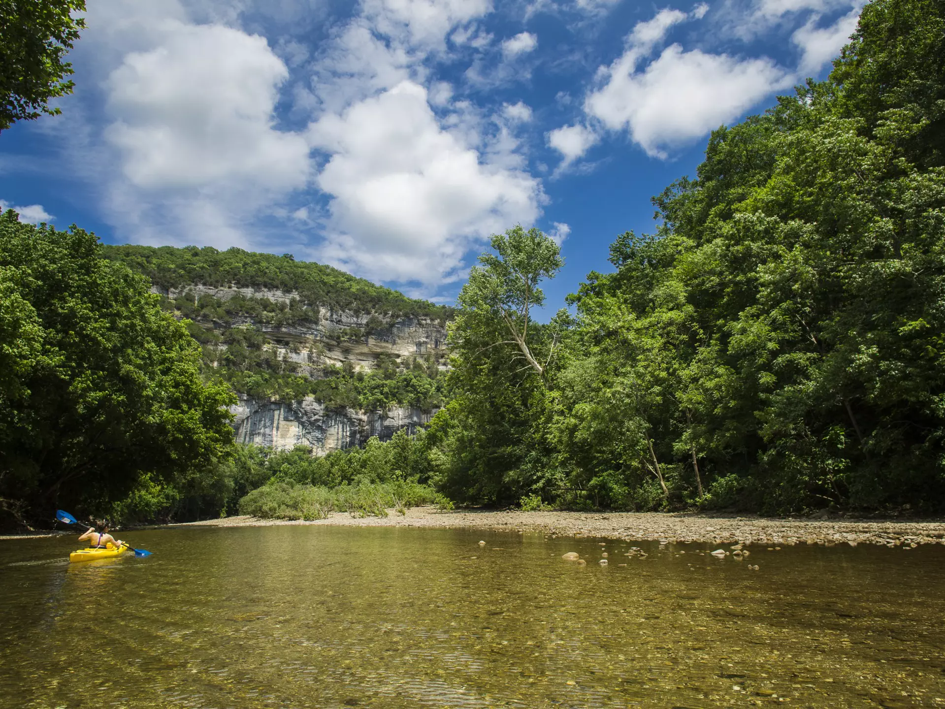 A view from the Buffalo River with a kayaker looking towards Big Bluff and the Goat Trail. Gunnar Rathbun/Shutterstock
