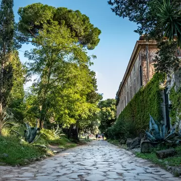The ancient Appian Way (Via Appia Antica) lined with stone and pine trees near Rome, Italy