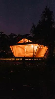 An open cabin is lit up at night.