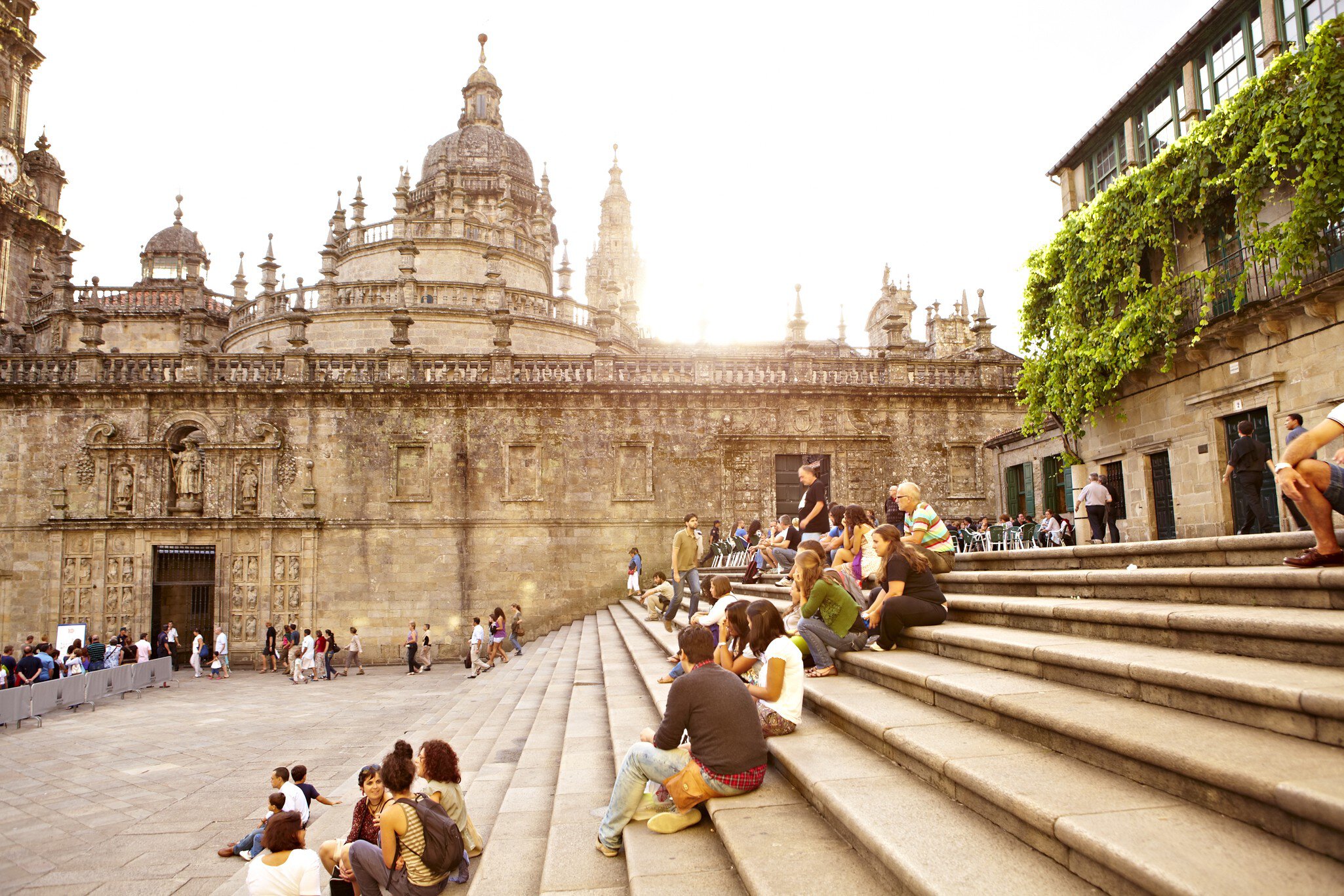 Visitors sitting on steps outside Santiago de Compostela Cathedral.