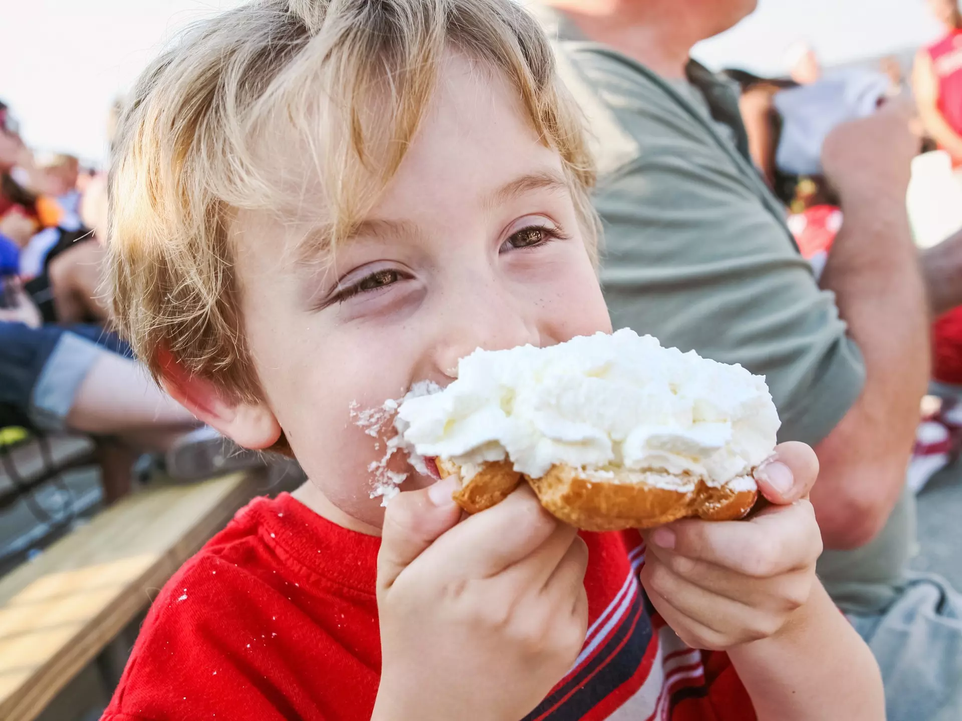 Young boy eating a whipped cream puff pastry at the Wisconsin State Fair, Milwaukee, Wisconsin, Great Lakes, USA