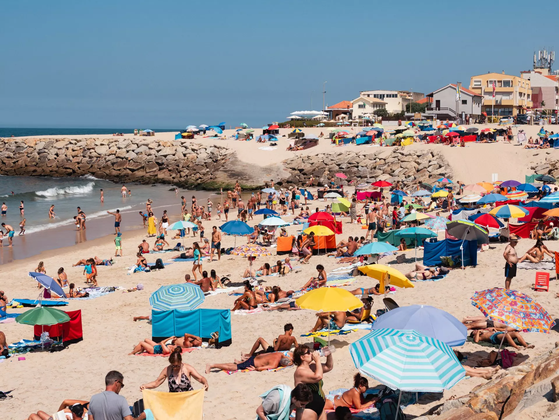 Sunseekers on Praia de Cortegaça beach in Portugal. 
