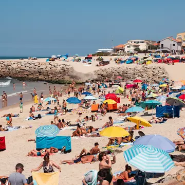 Sunseekers on Praia de Cortegaça beach in Portugal. 