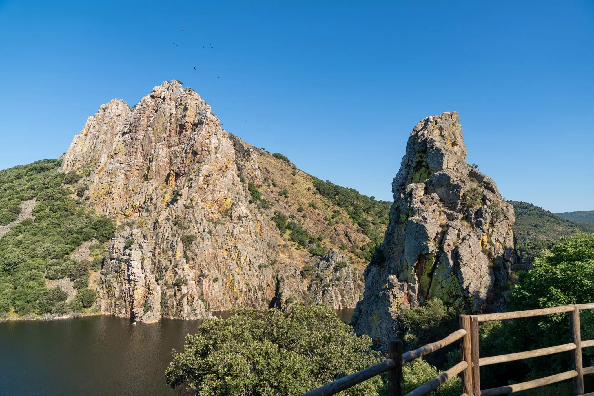 Aerial shot of rocky crags on either side of a body of water on a sunny day.