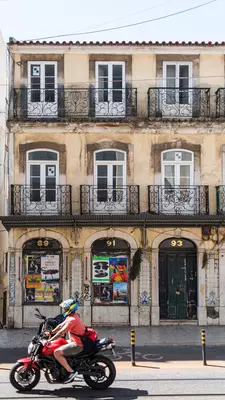A motorcycle travels through a city neighborhood