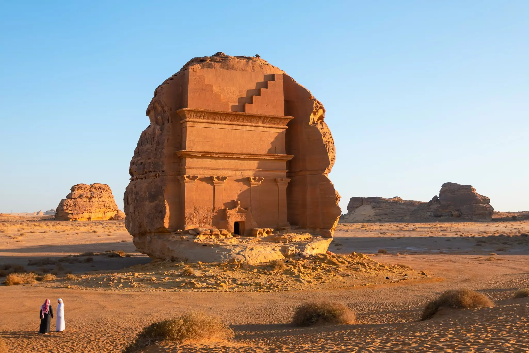 The Qasr al Farid tomb in Hegra, Saudi Arabia, surrounded by a rocky desert landscape. 