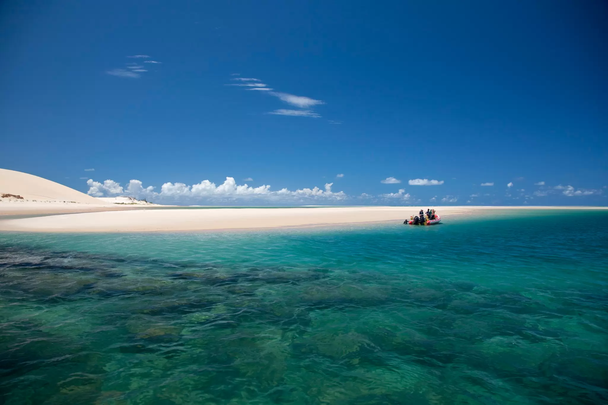 Mozambique, Bazaruto Archipelago. Divers kit up on a zodiac, ready to explore the stunning coral reefs off Benguerra Island.