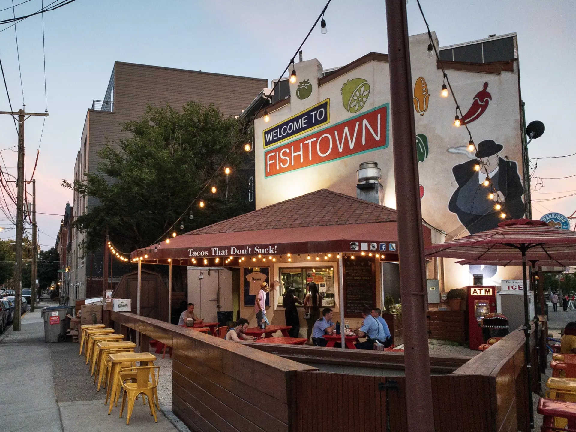A few people sit at tables at a restaurant with outdoor dining in  the Fishtown area of North Philadelphia