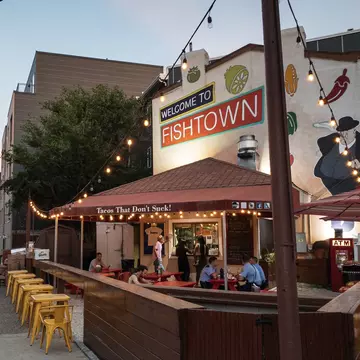 A few people sit at tables at a restaurant with outdoor dining in  the Fishtown area of North Philadelphia