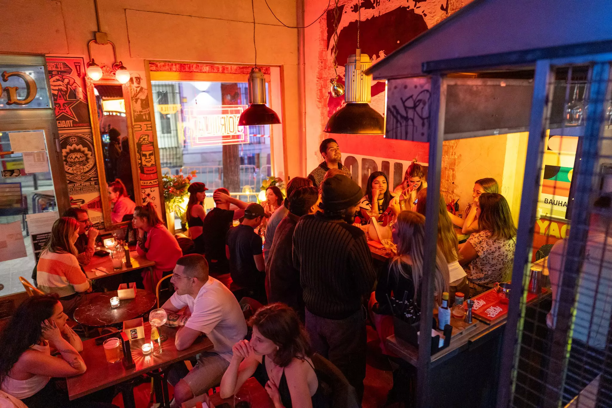 People sit at tables in a crowded bar.