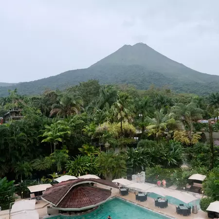 Views of Volcan Arenal from a guestroom balcony at the Royal Corin Hotel in La Fortuna, with the property's natural springs below
