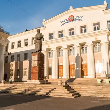 Statue of Byambyn Rinchen before the columned National Library of Mongolia, Ulaanbaatar; facade reads ҮНДЭСНИЙ НОМЫН САН