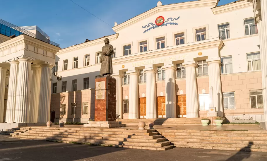 Statue of Byambyn Rinchen before the columned National Library of Mongolia, Ulaanbaatar; facade reads ҮНДЭСНИЙ НОМЫН САН