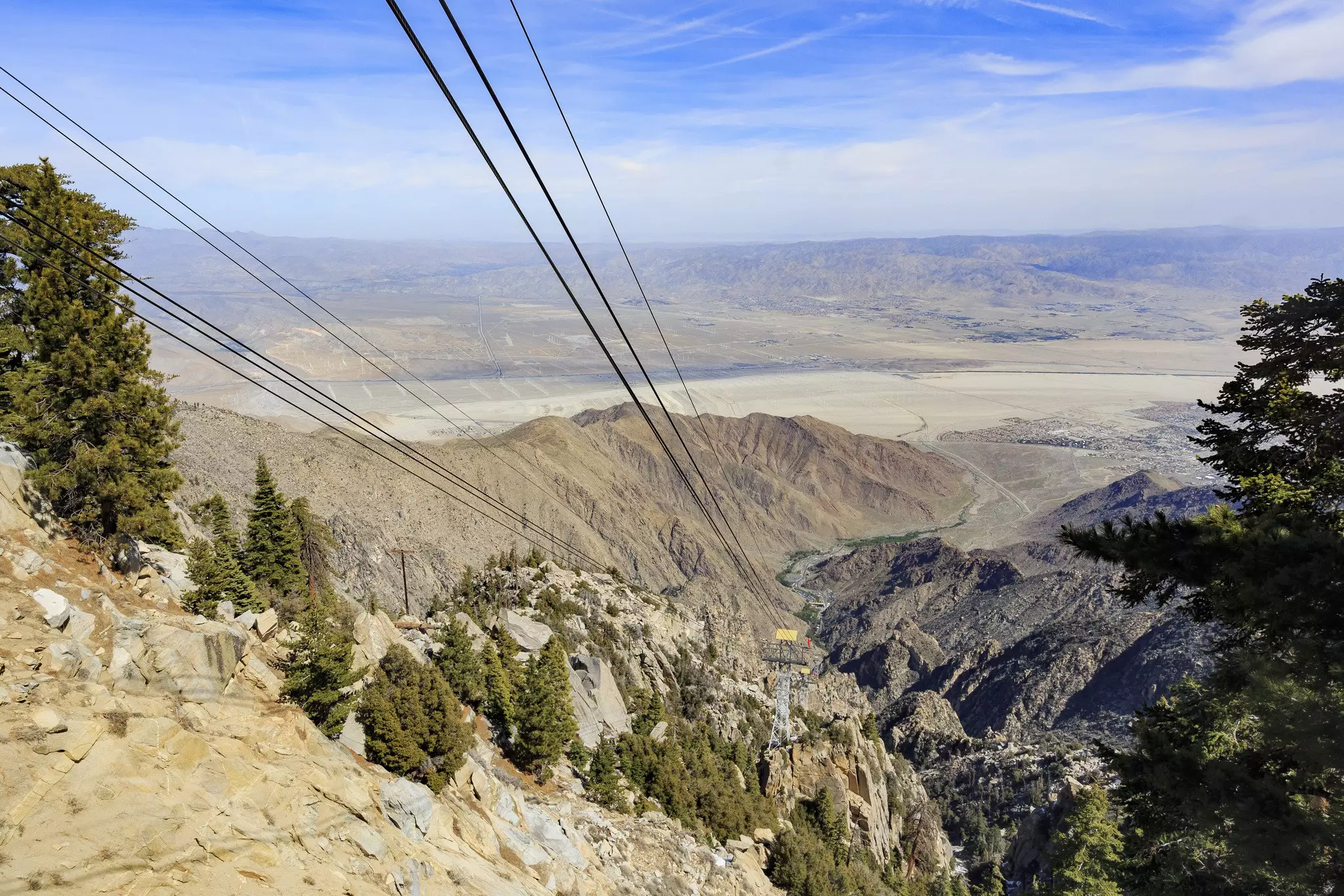A suspended tram through a dry valley.