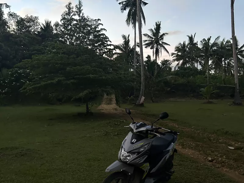 A motorcycle parked on a dirt road. 