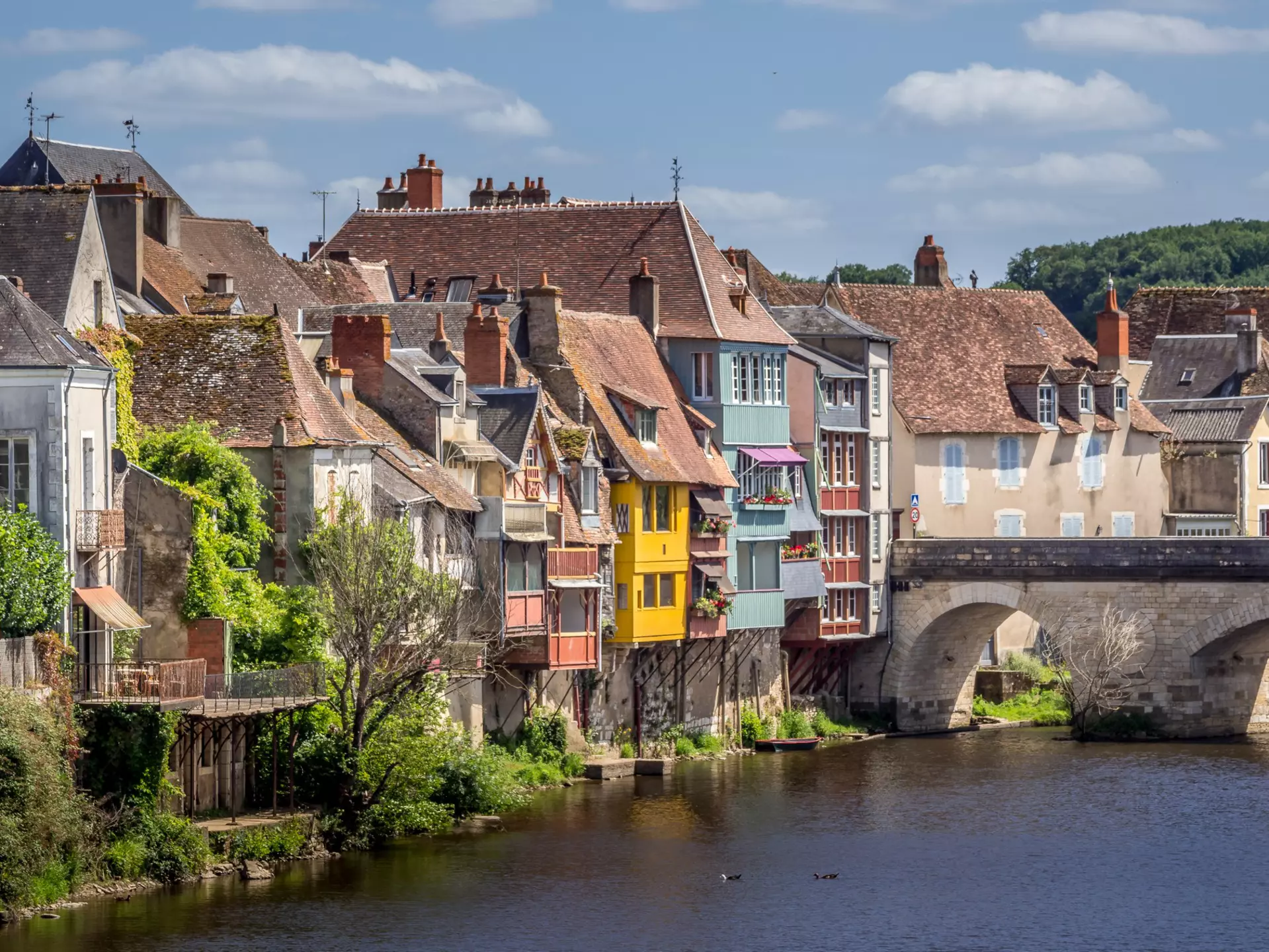 Brightly colored half-timbered houses overhanging a river in Argenton-sur-Creuse, France
