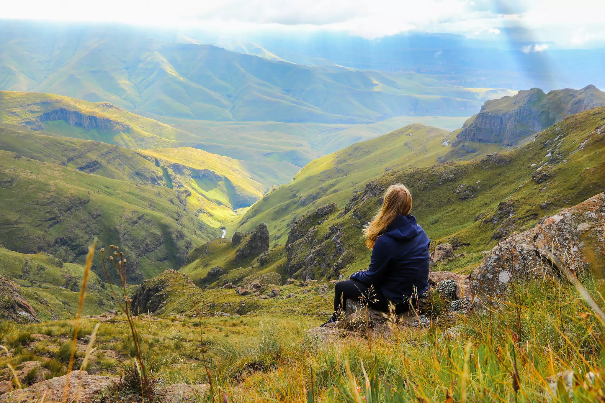 Woman contemplating the view from the top of the Sentinel Hike in the Drakensberg Mountains, Royal Natal National Park, Free State province of South Africa