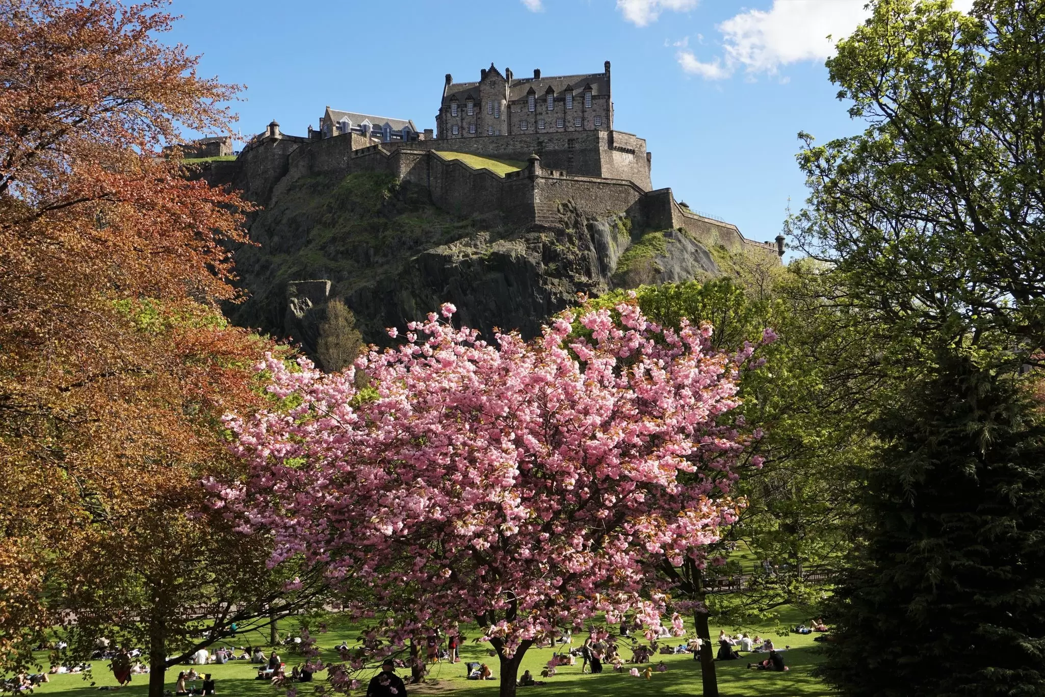 Costumed characters celebrate Beltane in Edinburgh by a huge fire.