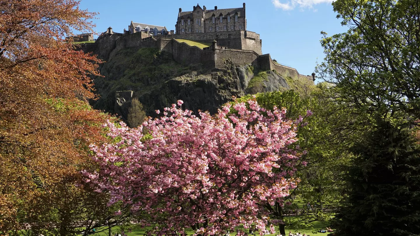 Costumed characters celebrate Beltane in Edinburgh by a huge fire.