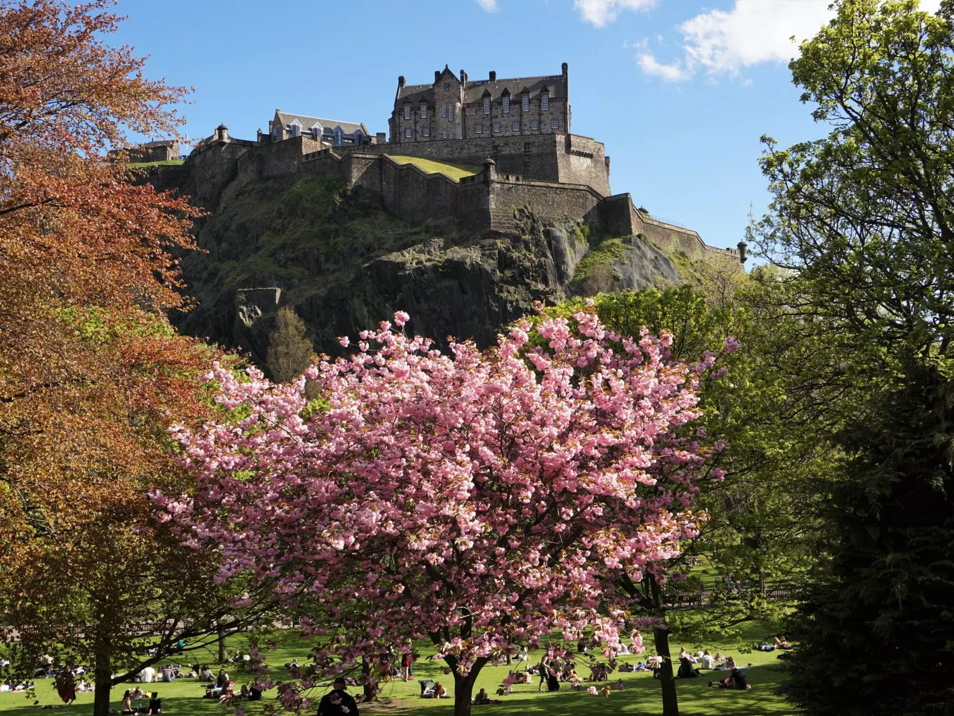 Costumed characters celebrate Beltane in Edinburgh by a huge fire.