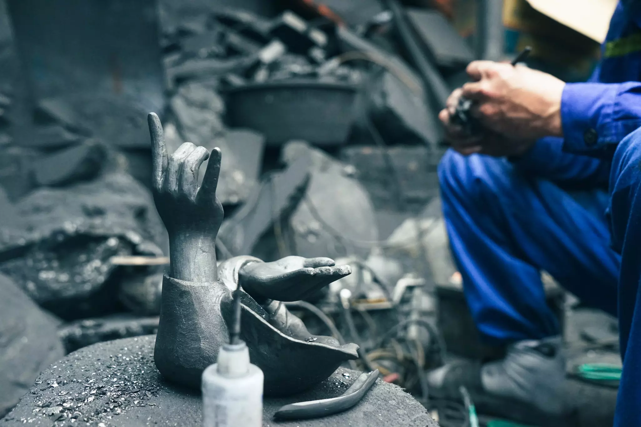 An artisan carving coal into the shape of human hands at a workshop in Halong City, Vietnam.