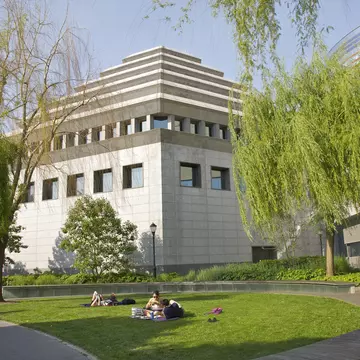 People on lawn near ziggurat building
