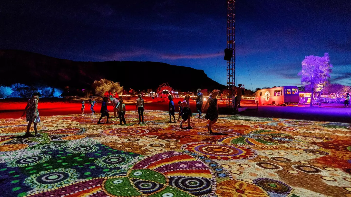 Visitors take in “Grounded” (“Ahelhe Itethe”) by Kathleen Wallace at Parrtjima, the authentic Aboriginal light festival in Alice Springs © courtesy Parrtjima / NTMEC