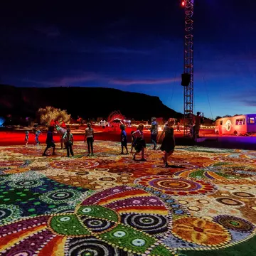 Visitors take in “Grounded” (“Ahelhe Itethe”) by Kathleen Wallace at Parrtjima, the authentic Aboriginal light festival in Alice Springs © courtesy Parrtjima / NTMEC