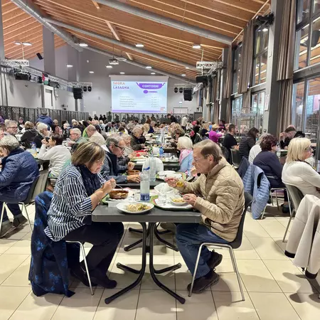 People on long folding tables eat