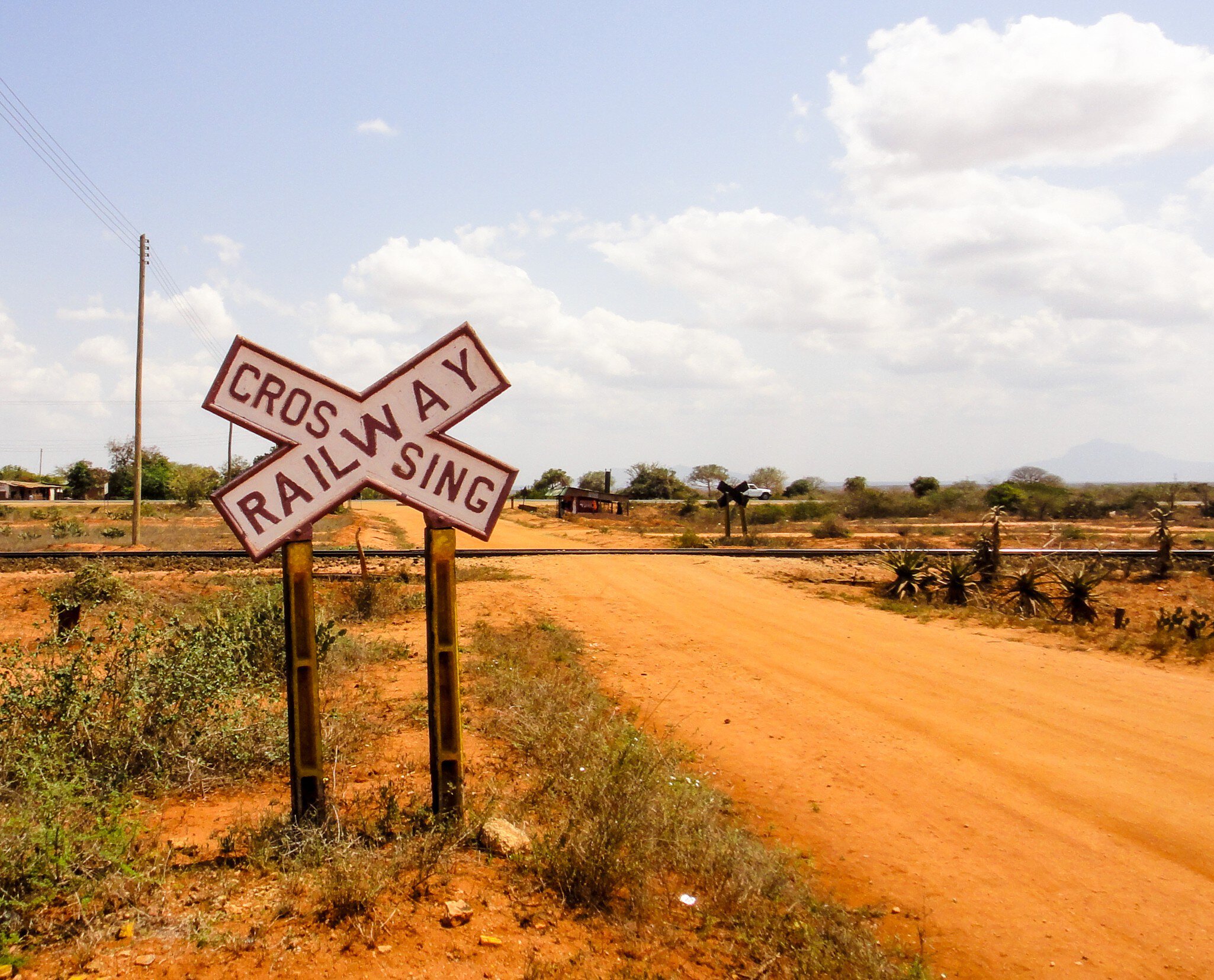 A large black-and-white cross-shaped sign reads