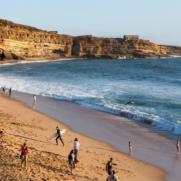 Beachgoers and surfers along Portugal's coast